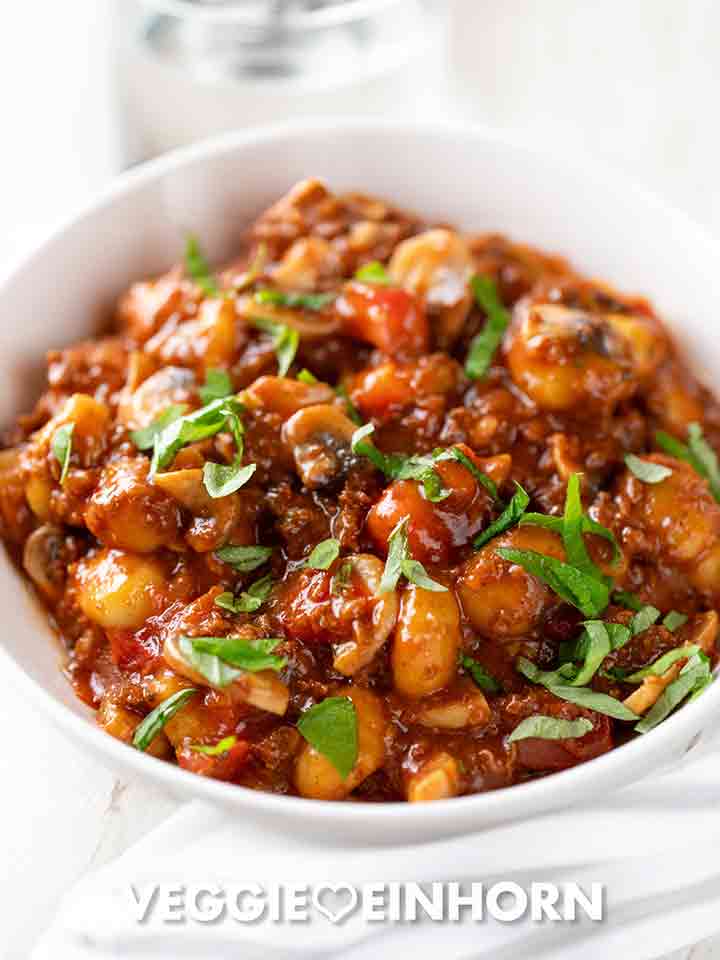 Vegane Gnocchi Pfanne mit Hackfleisch, Pilzen und Tomaten auf einem Teller