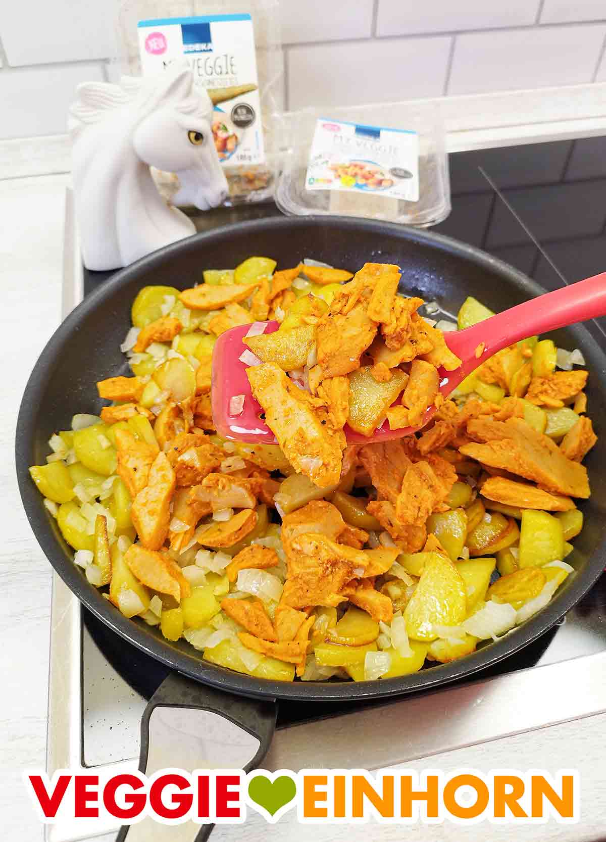 Die Gyrospfanne mit Kartoffeln, Gyros von EDEKA My Veggie und Zwiebeln ist vegan. Pfannenwender in einer Pfanne mit veganem Gyros von Edeka My Veggie, Kartoffeln und Zwiebeln