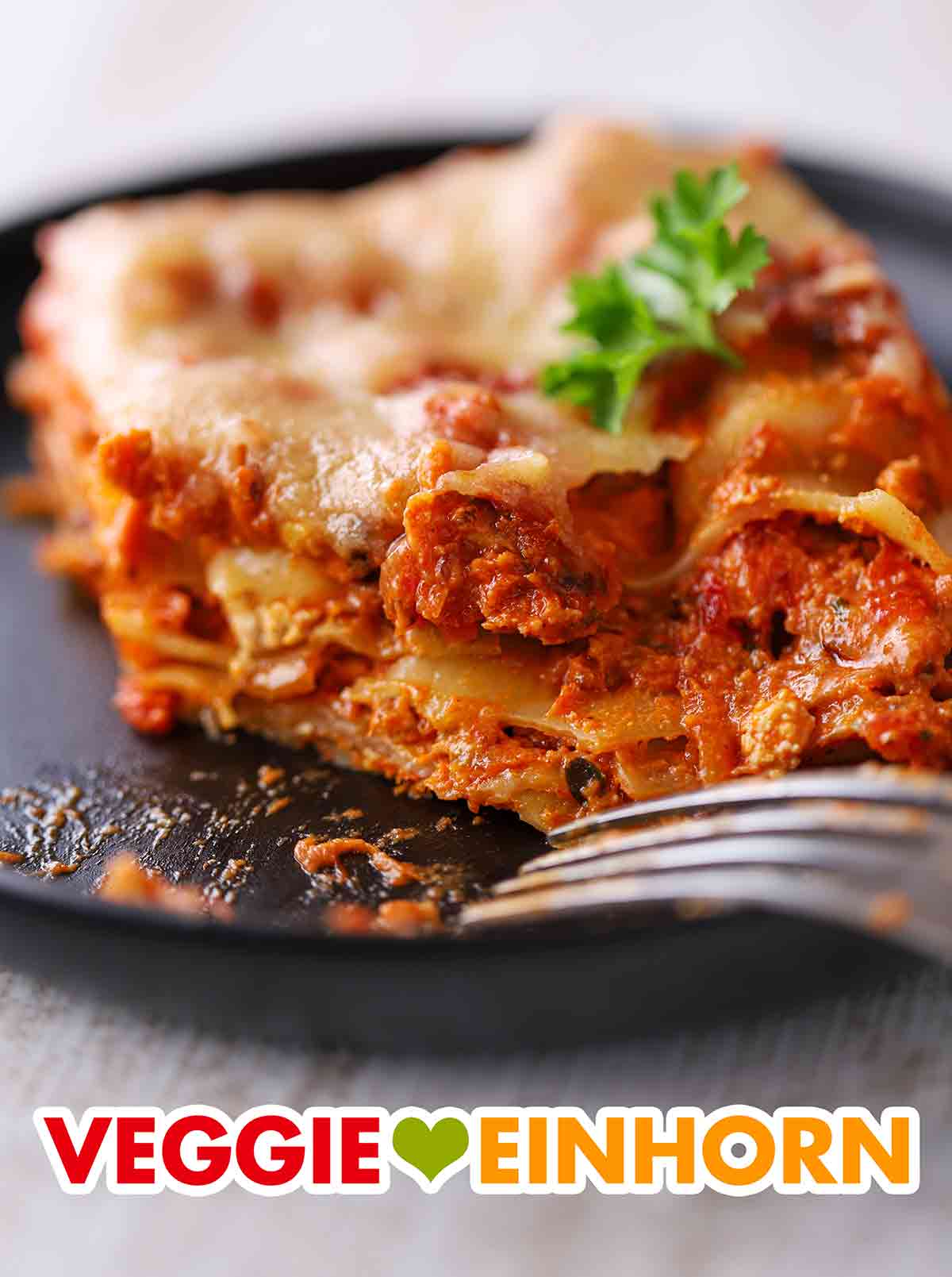Die Tofu Lasagne ist saftig und aromatisch. Angeschnittenes Stück Tofu Lasagne auf einem Teller