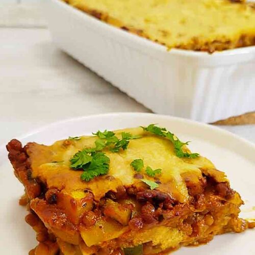 Teller mit einem Stück veganer Linsenlasagne mit Zucchini