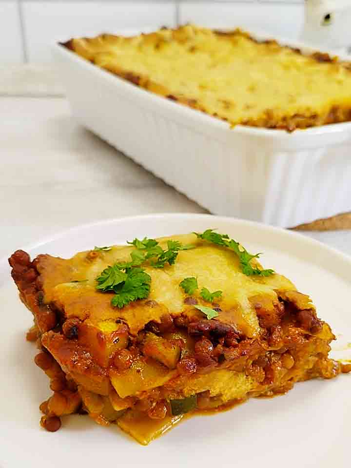 Teller mit einem Stück veganer Linsenlasagne mit Zucchini