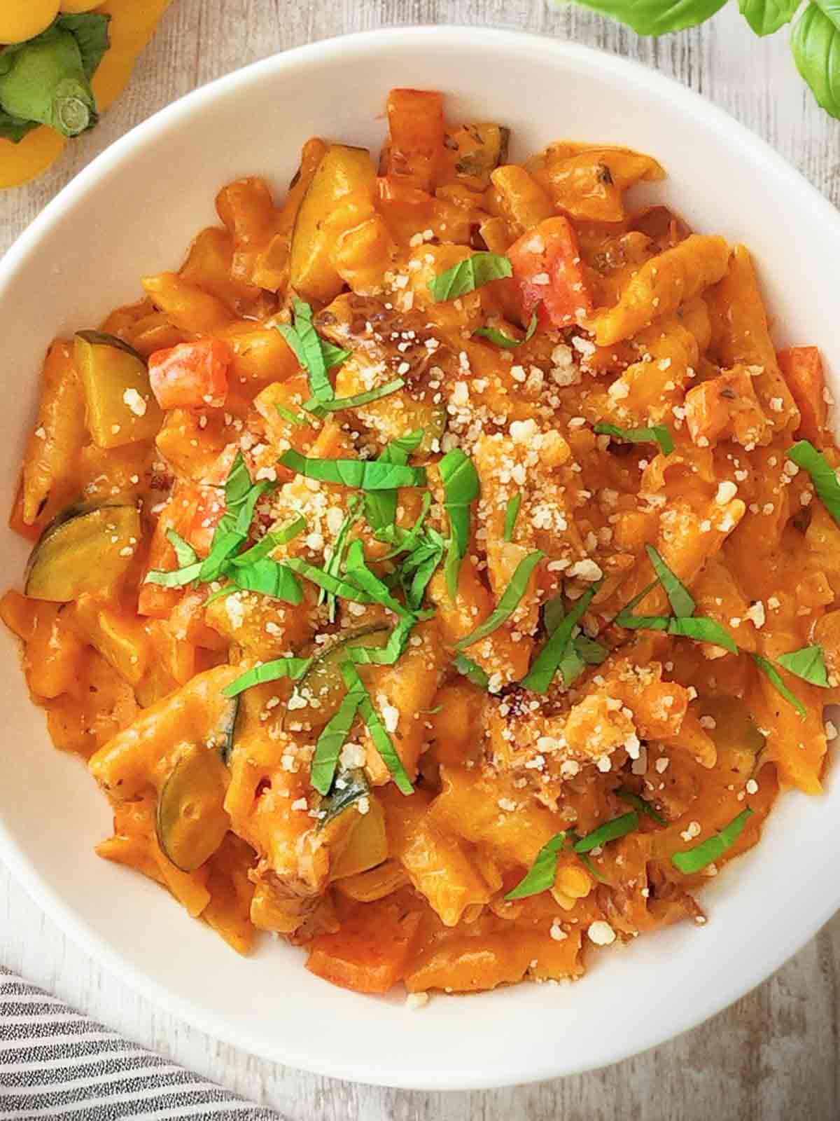 Teller mit veganer One Pot Pasta mit Paprika, Zucchini und getrockneten Tomaten