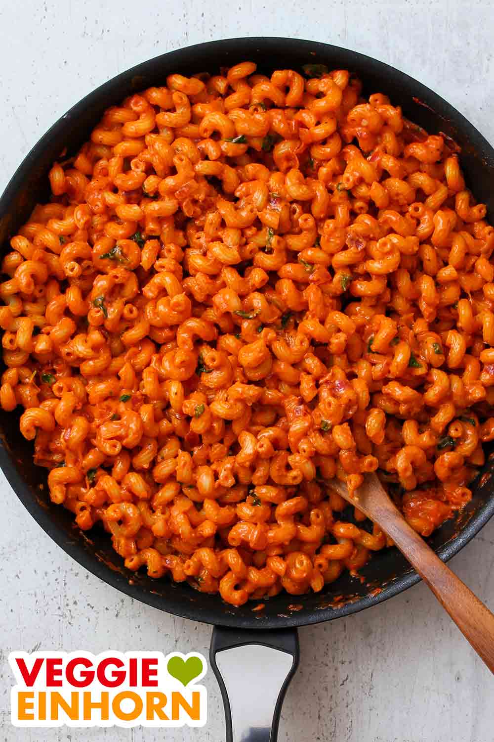 Nudeln mit Tomatenmark und Kokosmilch in einer Pfanne Eine Pfanne mit Cellentani mit Tomatenmark und Kokosmilch