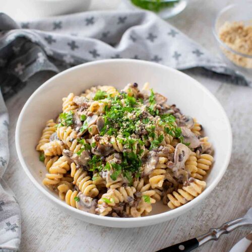 Teller mit schneller veganer Nudelpfanne mit Champignons und Linsen