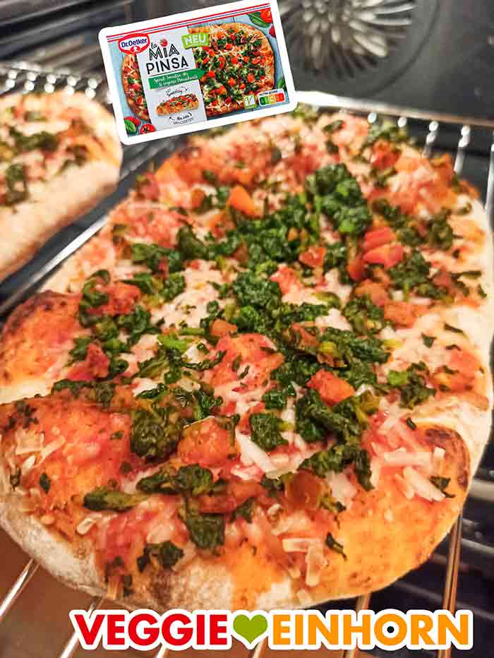 Auf der Pizza ist viel Spinat, getrocknete Tomaten und veganer Käse. Die Pizza La Mia Pinsa von Dr. Oetker auf dem Rost im Backofen