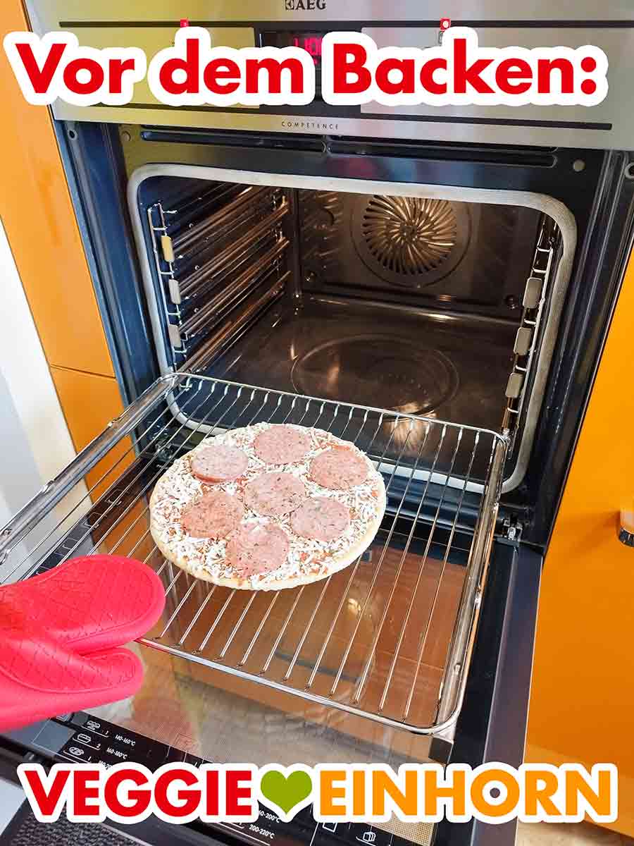 Die tiefgekühlte Pizza Ristorante mit veganer Salami wird in den Ofen geschoben. Die vegane Salami Pizza von Dr. Oetker auf dem Backofenrost vor dem Backen