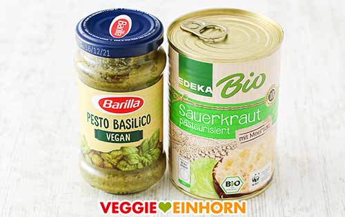 Veganes Pesto und Sauerkraut enthalten vegane Milchsäure. Ein Glas veganes Pesto und eine Dose Sauerkraut