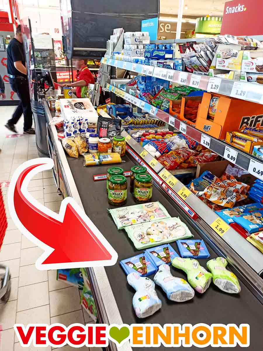 Vegane Süßigkeiten und vegane Schokoladentafeln auf dem Kassenband Vegane Schokolade von Ritter Sport und andere vegane Süßigkeiten an der Supermarktkasse