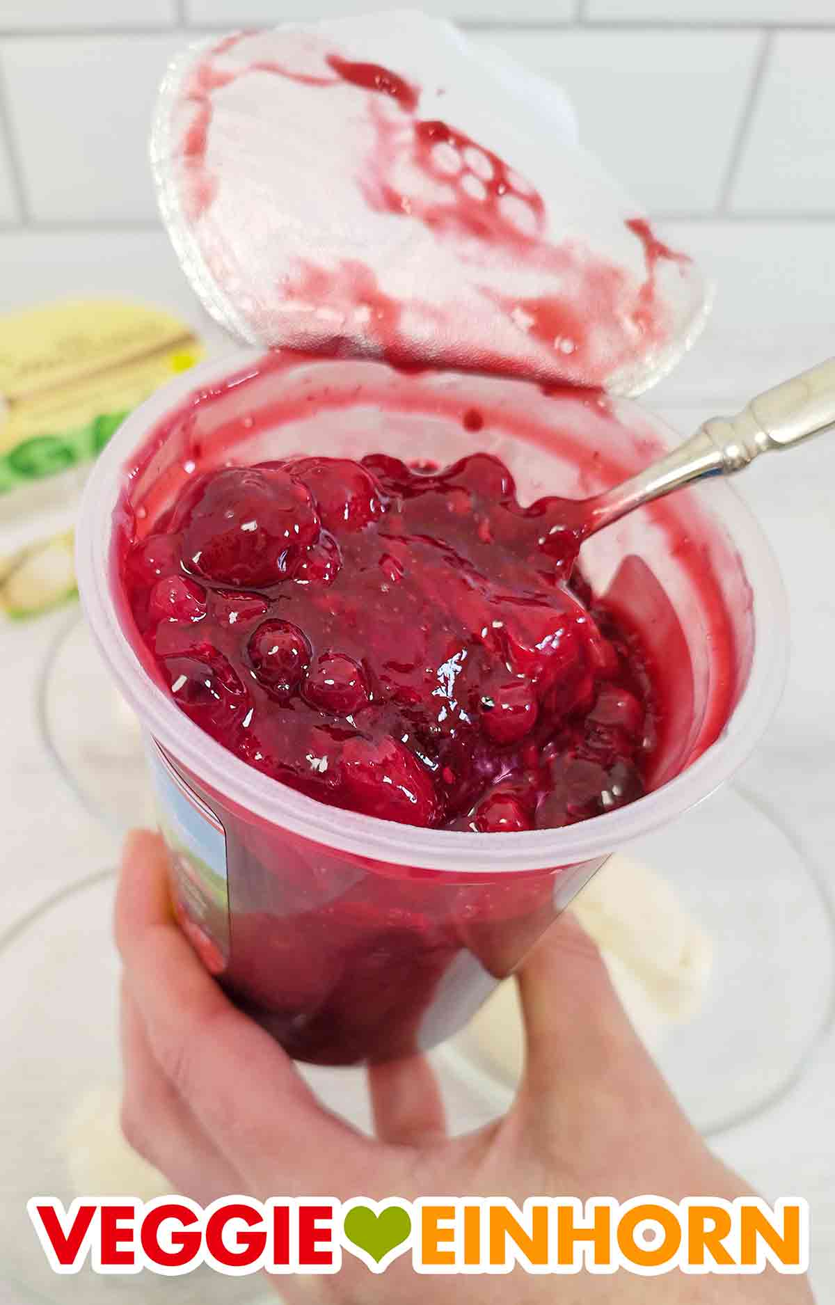 So sieht die rote Grütze von Dr. Oetker Löffelglück aus. Löffel im Becher mit veganer roter Grütze von Dr. Oetker