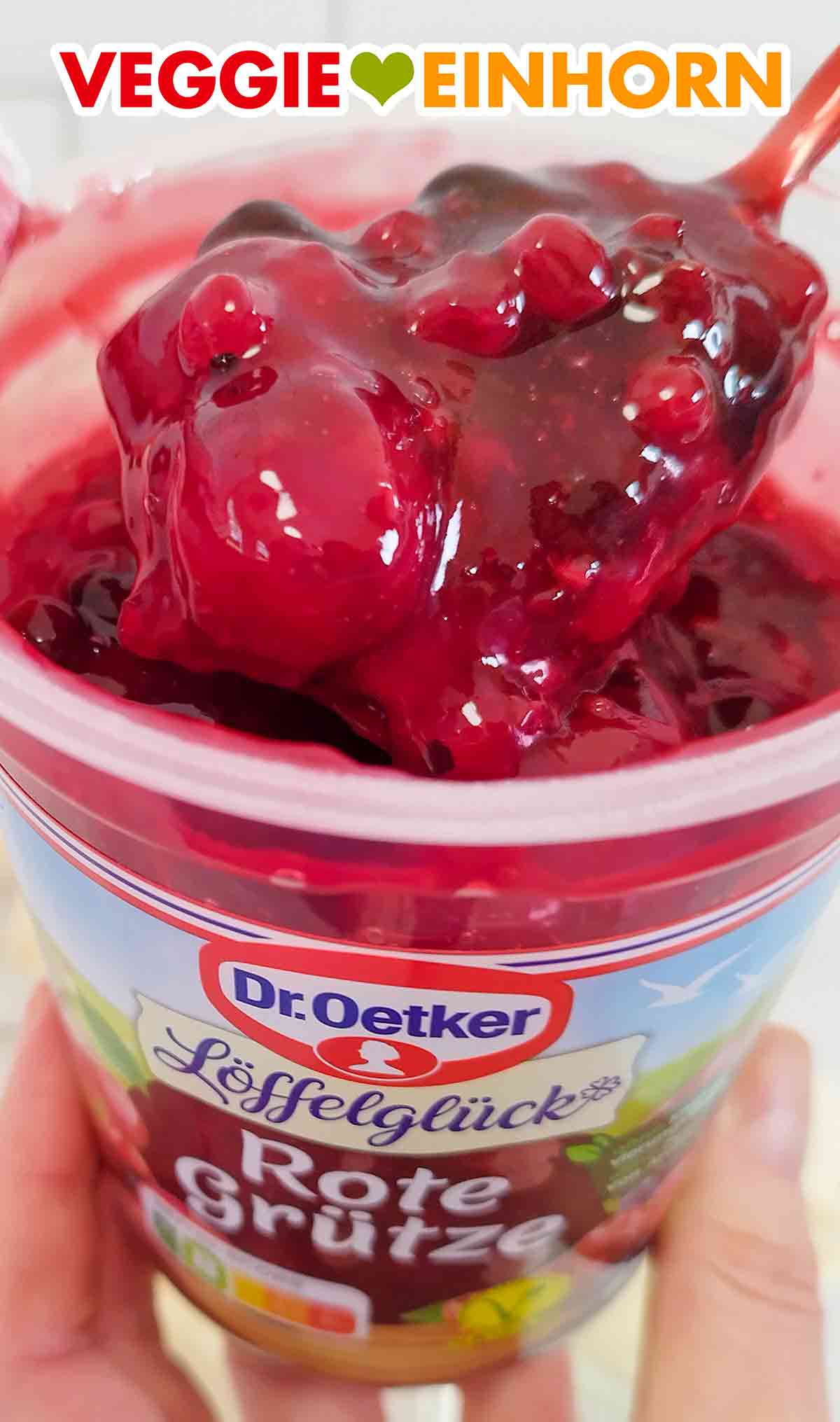 Ein Löffel rote Grütze von Dr. Oetker mit Sauerkirschen und Johannisbeeren Nahaufnahme der veganen roten Grütze von Dr. Oetker Löffelglück