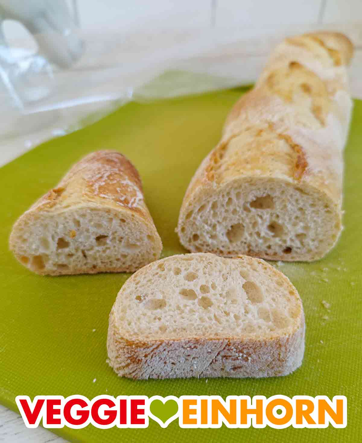 Die Rustiguette ist ein ganz normales Baguette. Angeschnittene Rustiguette auf einem Schneidebrett