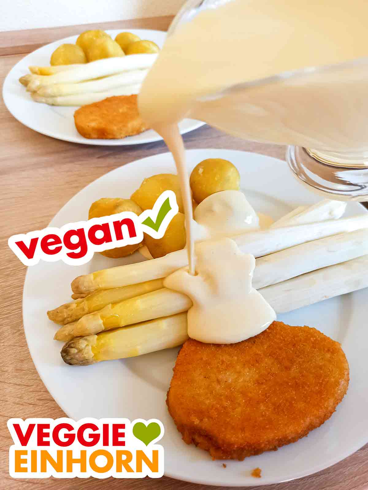 Die vegane Sauce Hollandaise von bedda passt ideal zu Spargel, Kartoffeln und veganem Mühlen Schnitzel. Die vegane Sauce Hollandaise von bedda wird auf einen Teller mit Spargel, Kartoffeln und veganem Schnitzel gegossen.