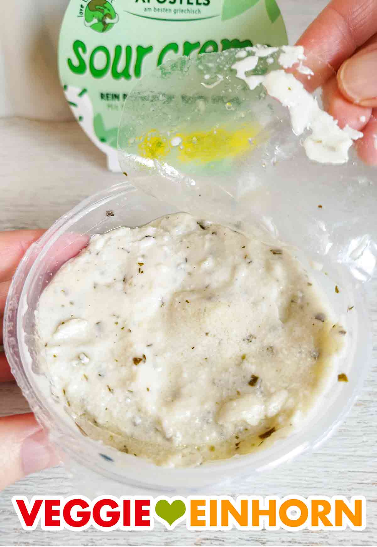 Abziehen der Deckelfolie Die Folie der veganen Sour Creme von Apostels wird abgezogen