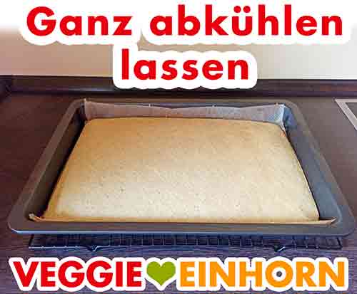 Der Biskuit kühlt ab. Blech mit veganem Biskuit auf einem Abkühlgitter.