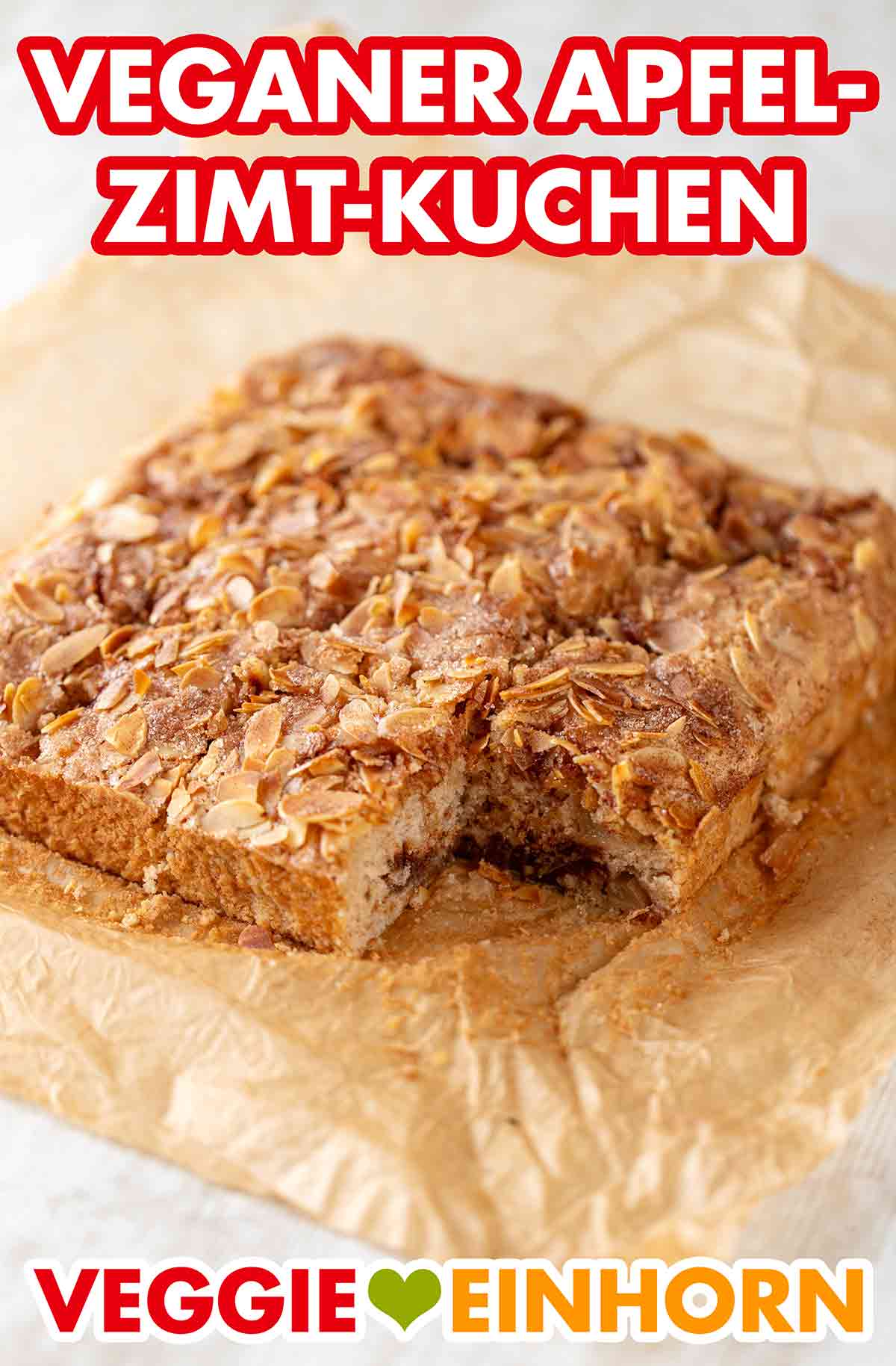 Der saftige Apfel-Zimt-Kuchen ist mit Mandelblättchen bedeckt. Veganer Apfel-Zimt-Kuchen auf einem Stück Backpapier