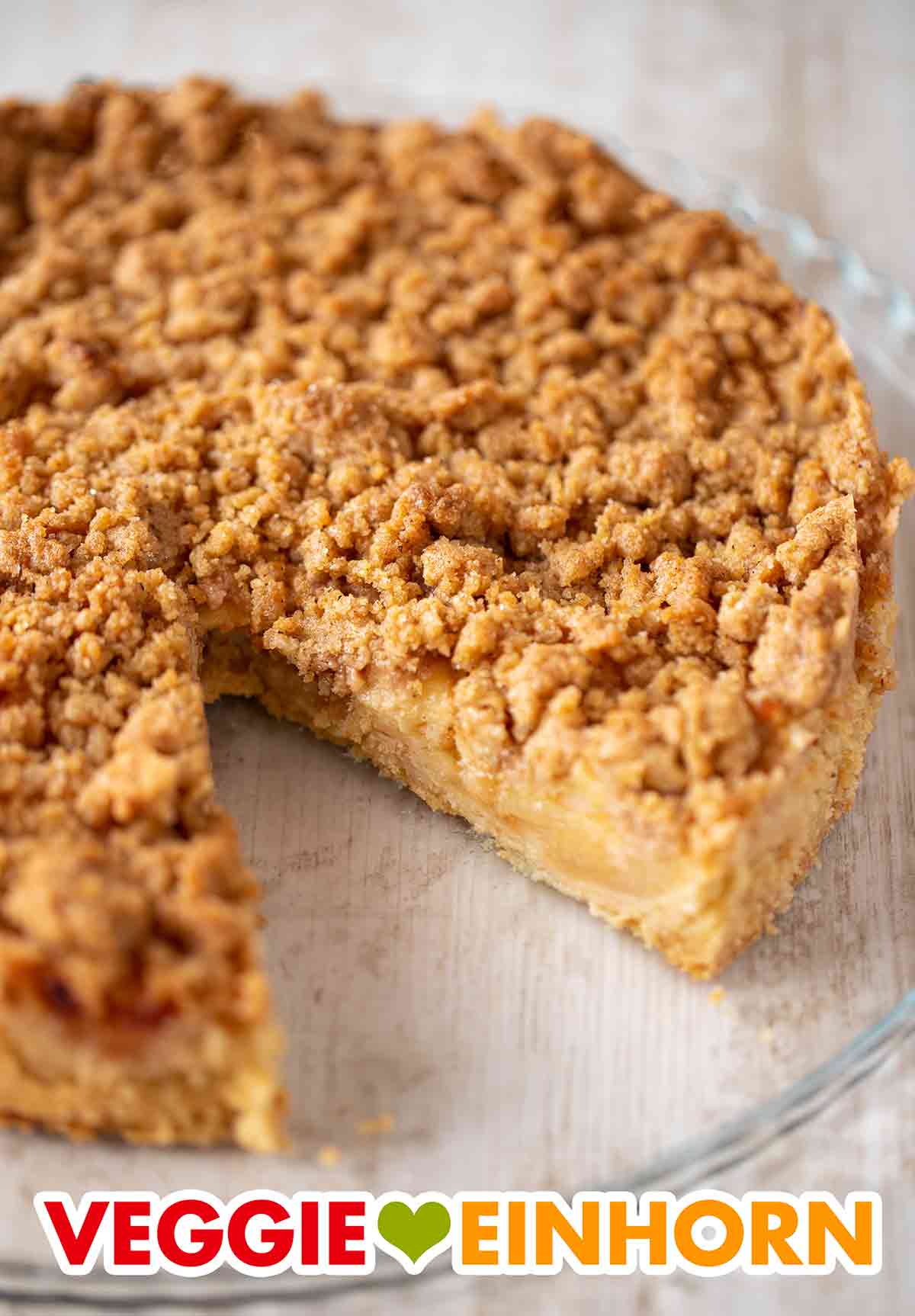 Der vegane Apfelkuchen mit Mürbeteig hat leckere Zimtstreusel. Kuchenplatte mit veganem Apfel Streuselkuchen mit Mürbeteig