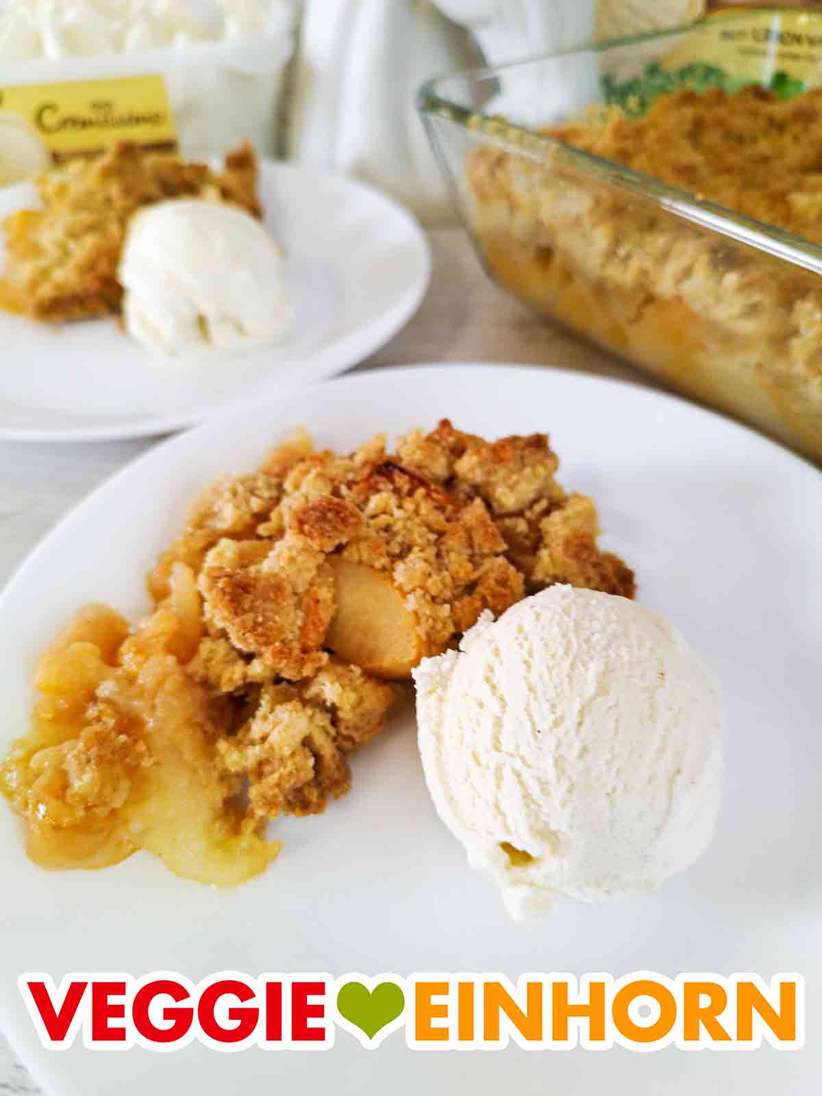 Eine Portion Apple Crumble mit einer Kugel veganem Vanilleeis von Langnese Cremissimo. Dessertteller mit veganem Apfel Crumble und Vanilleeis