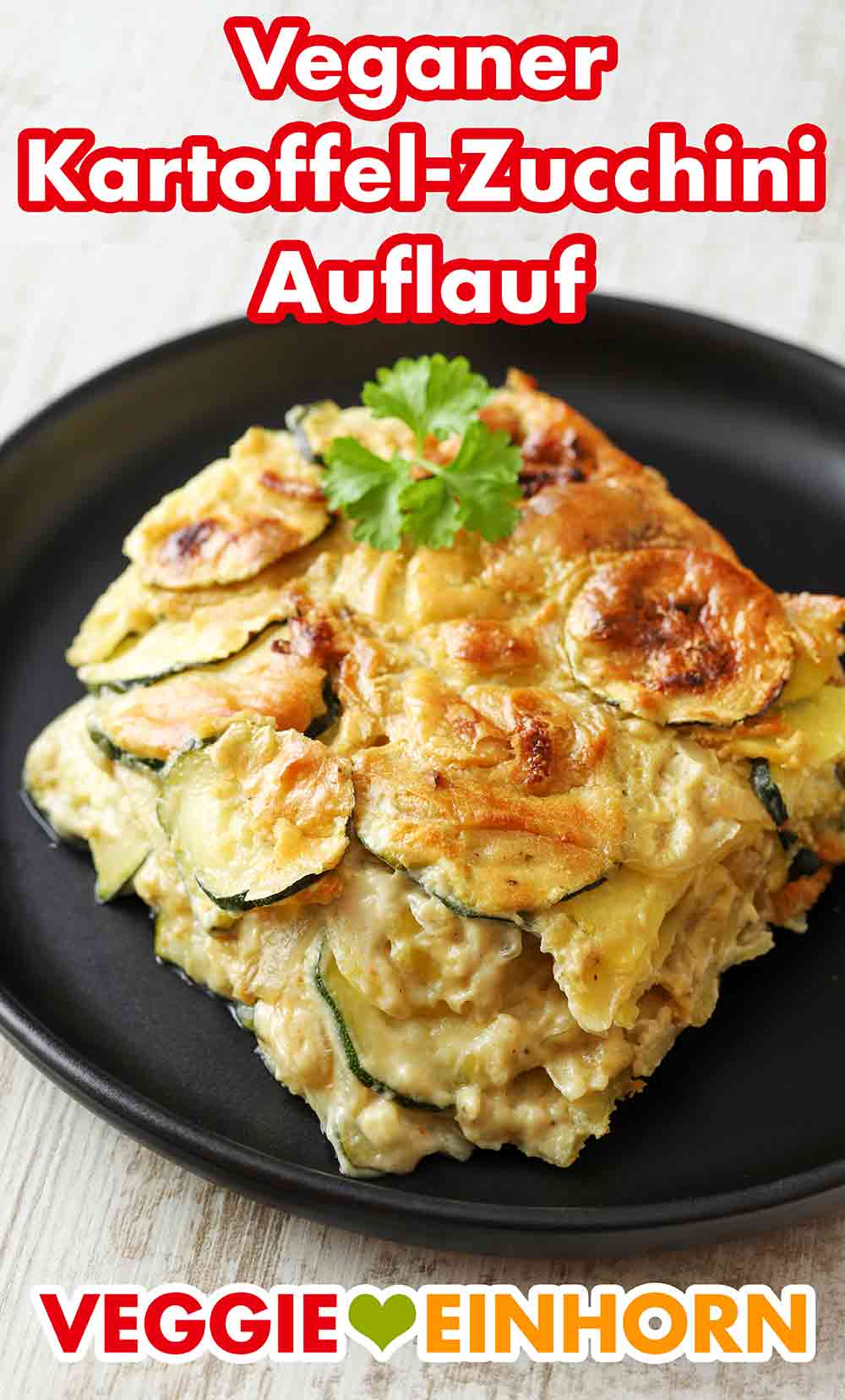 Der vegane Zucchini Kartoffel Auflauf ist fertig. Teller mit veganem Kartoffel Zucchini Auflauf