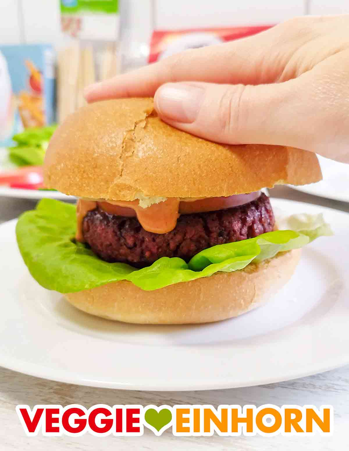 Die vegane Burgersoße läuft über den veganen Patty. Veganer Burger mit einem Patty von Penny, Brötchen von Block House und Bugersoße