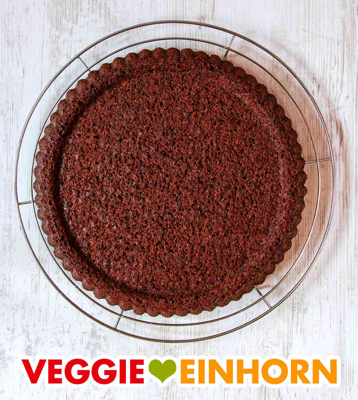 Der vegane dunkle Obstboden ist locker und saftig. Rundes Kuchengitter mit einem veganen dunklen Obstboden