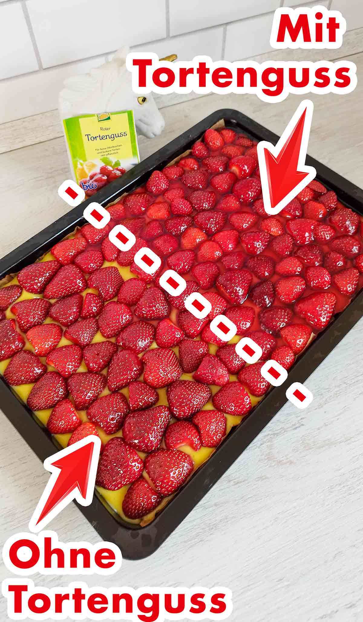 Auf der einen Hälfte ist Tortenguss, auf der anderen Hälfte nicht. Veganer Erdbeerkuchen vom Blech zur Hälfte mit rotem Tortenguss