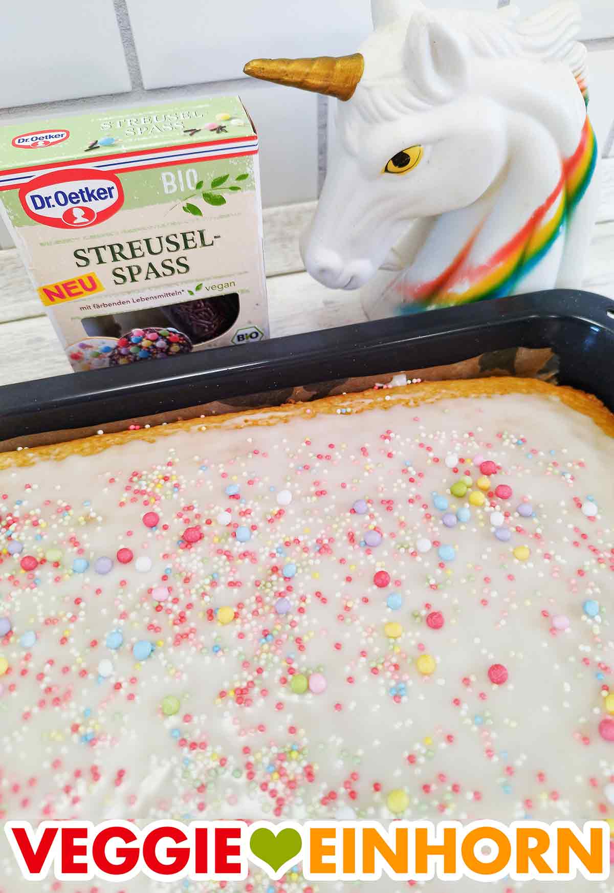 Veganer Fantakuchen auf dem Backblech dekoriert mit veganen bunten Zuckerstreuseln Fantakuchen ohne Ei mit veganen Zuckerstreuseln