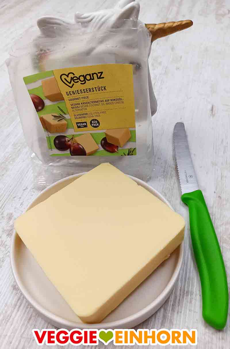 Der vegane Gouda Käse Block von Veganz auf einem Teller Ausgepacktes Veganz Genießerstück auf einem Teller