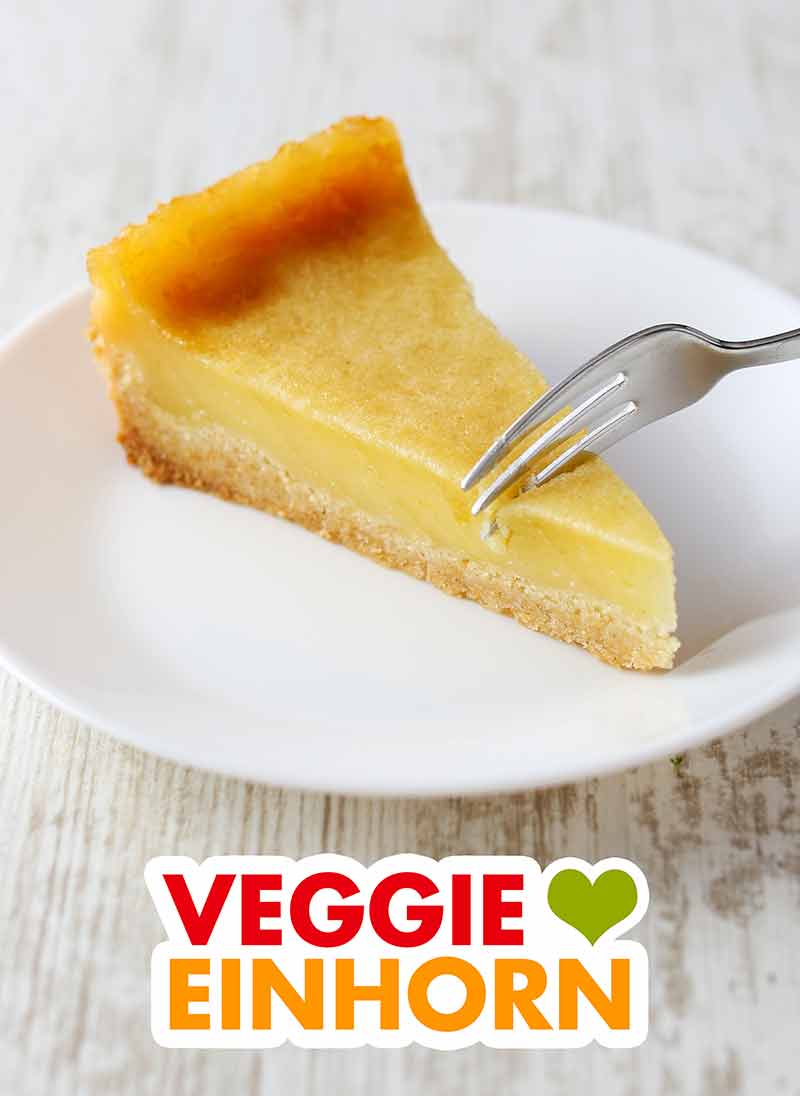 Der vegane Käsekuchen ohne Soja ist sehr lecker. Ein Stück veganer Käsekuchen mit Kokosjoghurt auf einem Teller mit einer Gabel