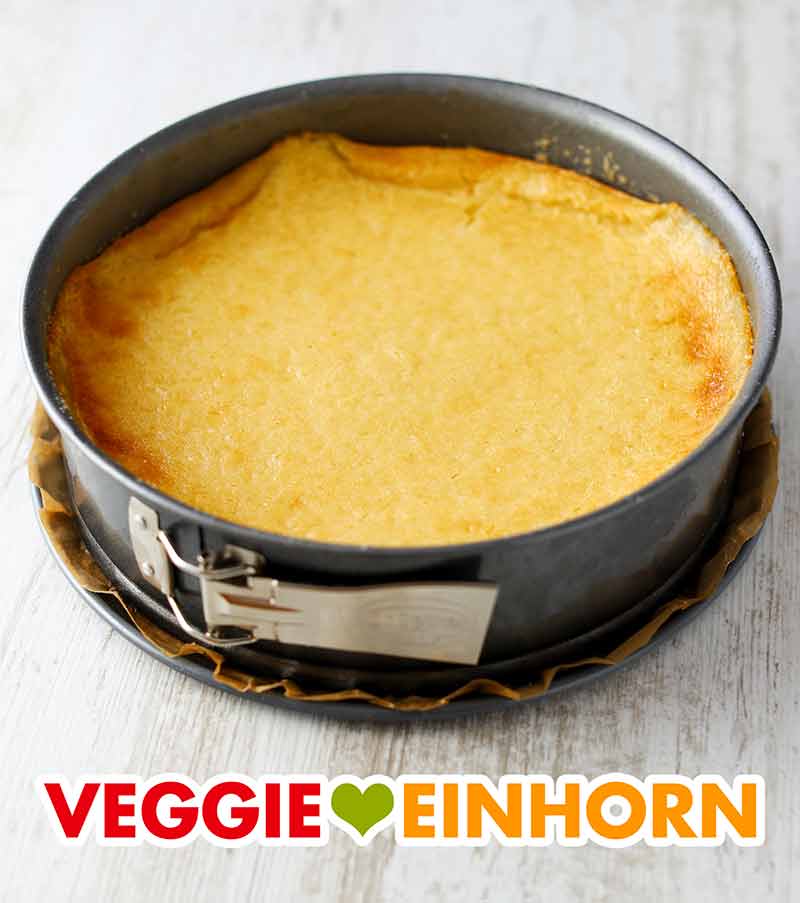 Der Käsekuchen ohne Soja ist fertig gebacken. Springform mit fertig gebackenen veganen Käsekuchen mit Kokosjoghurt