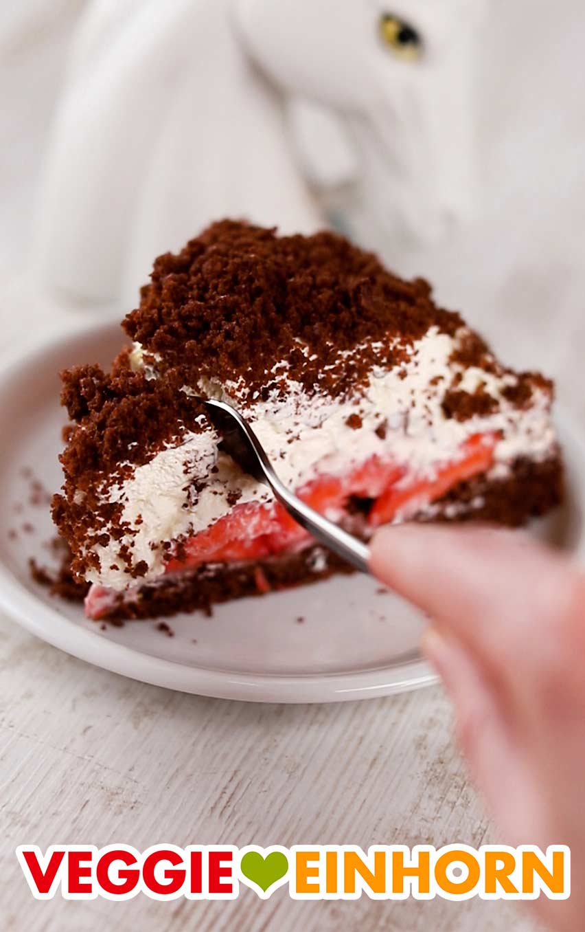Die vegane Maulwurftorte mit Erdbeeren kommt immer gut an. Kuchengabel in einem Stück veganem Maulwurfkuchen mit Erdbeeren