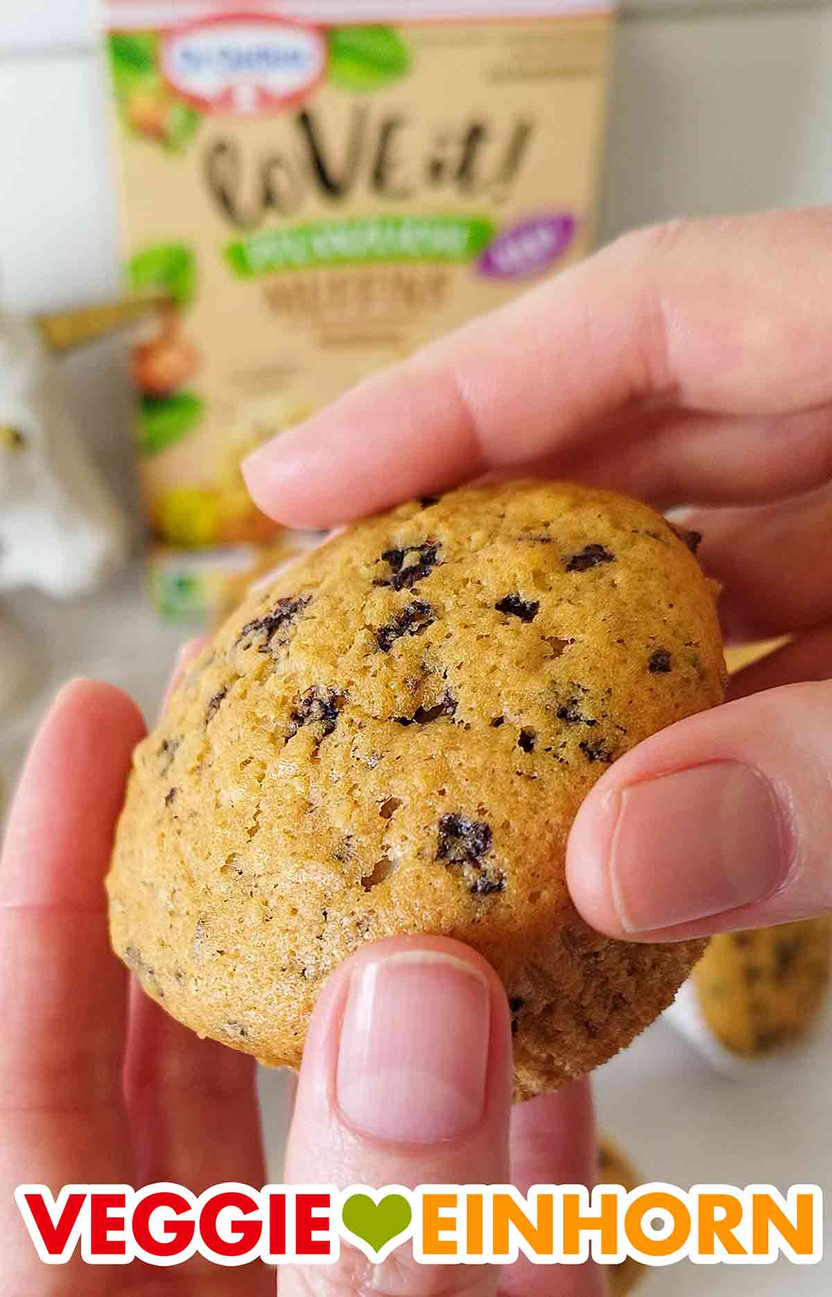 Der Muffin ist aus der LoVE it! Backmischung für pflanzliche Haselnuss-Muffins von Dr. Oetker. Zwei Hände halten einen veganen Muffin von Dr. Oetker
