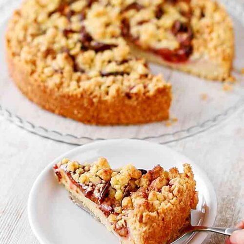 Veganer Pflaumenkuchen mit Streuseln und Pudding wird serviert