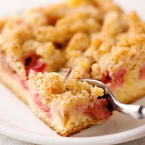 Veganer Rhabarber Streuselkuchen vom Blech mit einer Kuchengabel