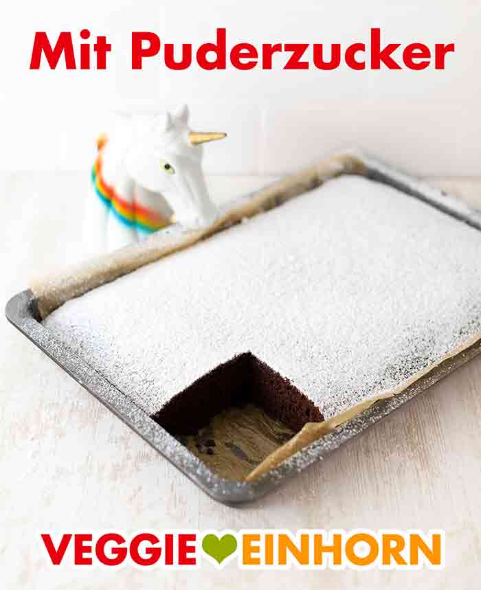Du kannst den Kuchen auch mit Puderzucker bestreuen. Veganer Schokokuchen auf dem Backblech mit Puderzucker bestreut.
