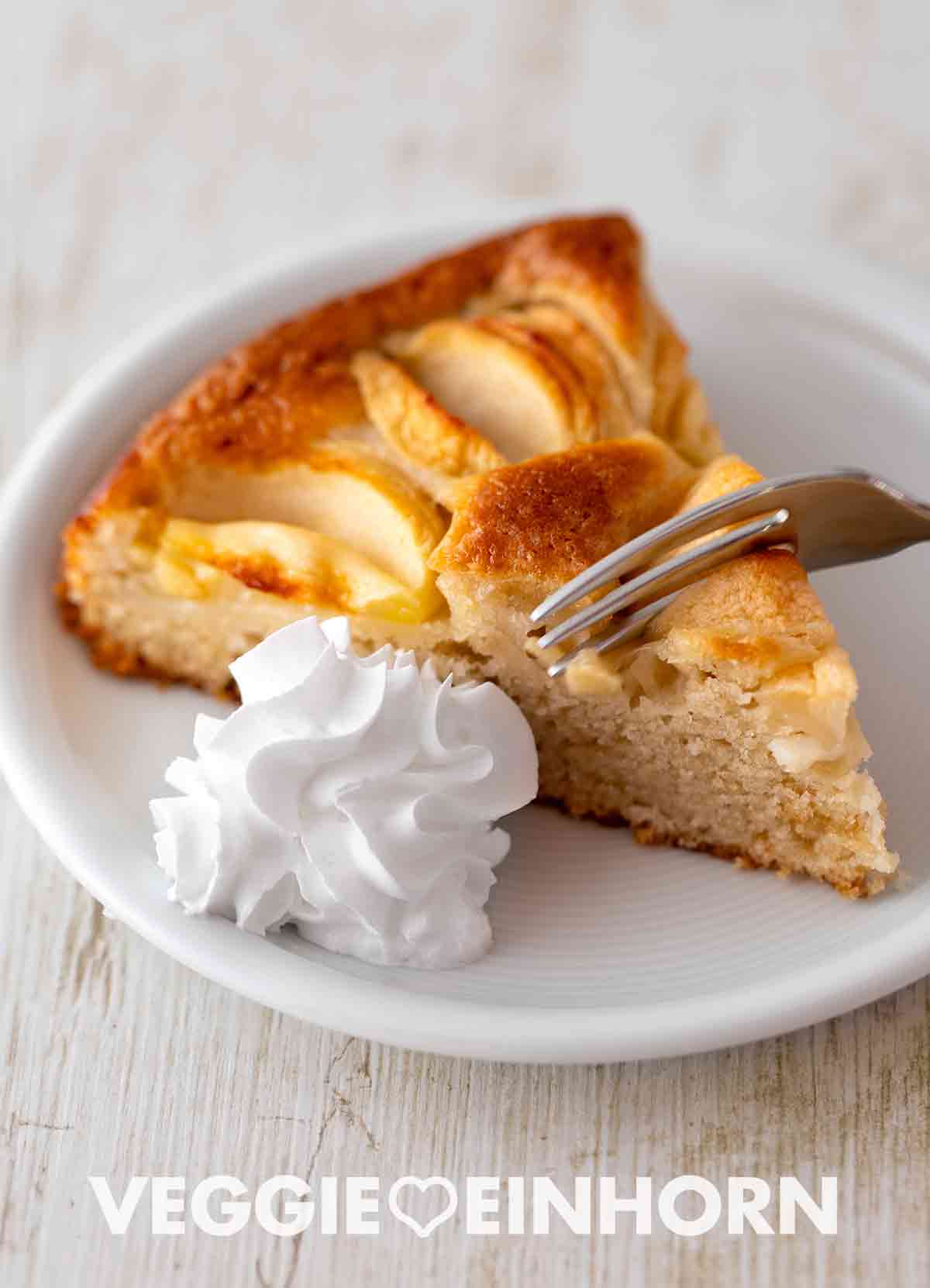Veganer versunkener Apfelkuchen ohne Ei Ein Stück saftiger veganer versunkener Apfelkuchen mit veganer Schlagsahne