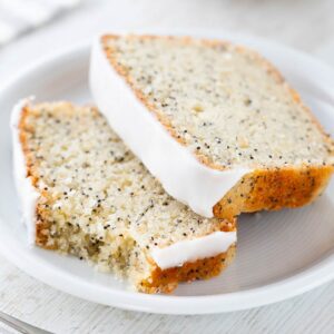 Zwei Stücke veganer Mohn Zitronen Kuchen auf einem Kuchenteller.
