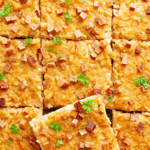Veganer Zwiebelkuchen aus Hefeteig auf einem Backblech