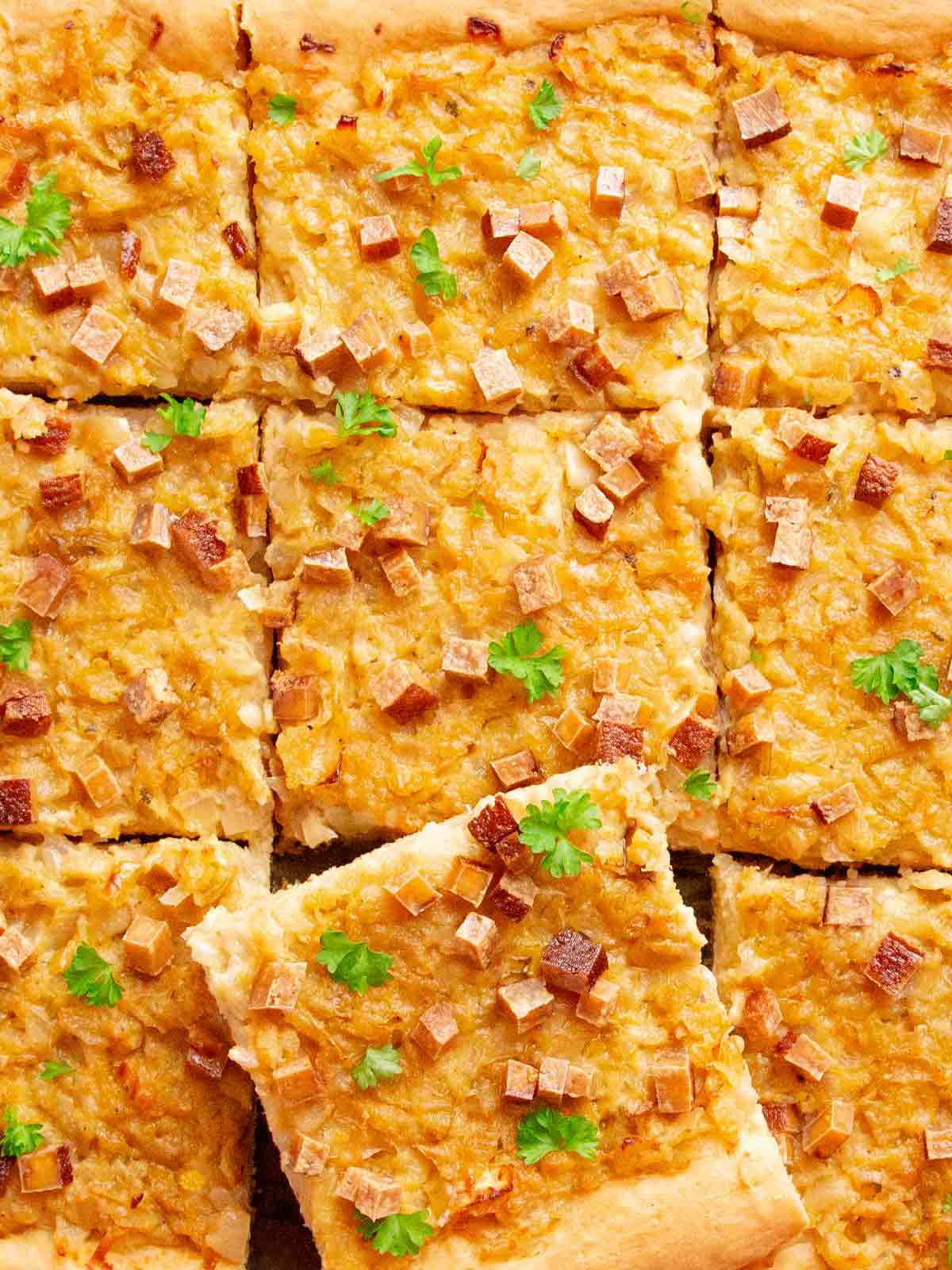 Veganer Zwiebelkuchen aus Hefeteig auf einem Backblech