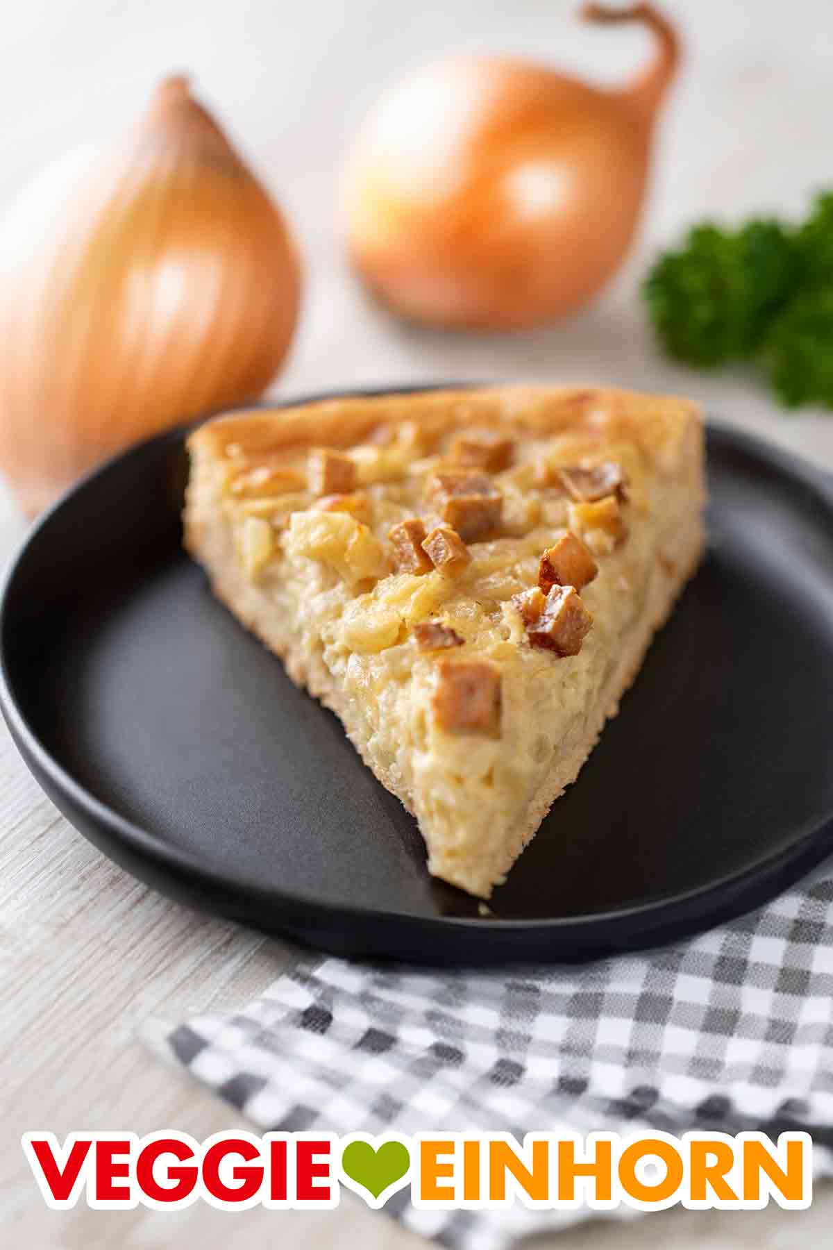Der Zwiebelkuchen mit Hefeteig ist vegetarisch und vegan. Ein Stück veganer Zwiebelkuchen mit Räuchertofu