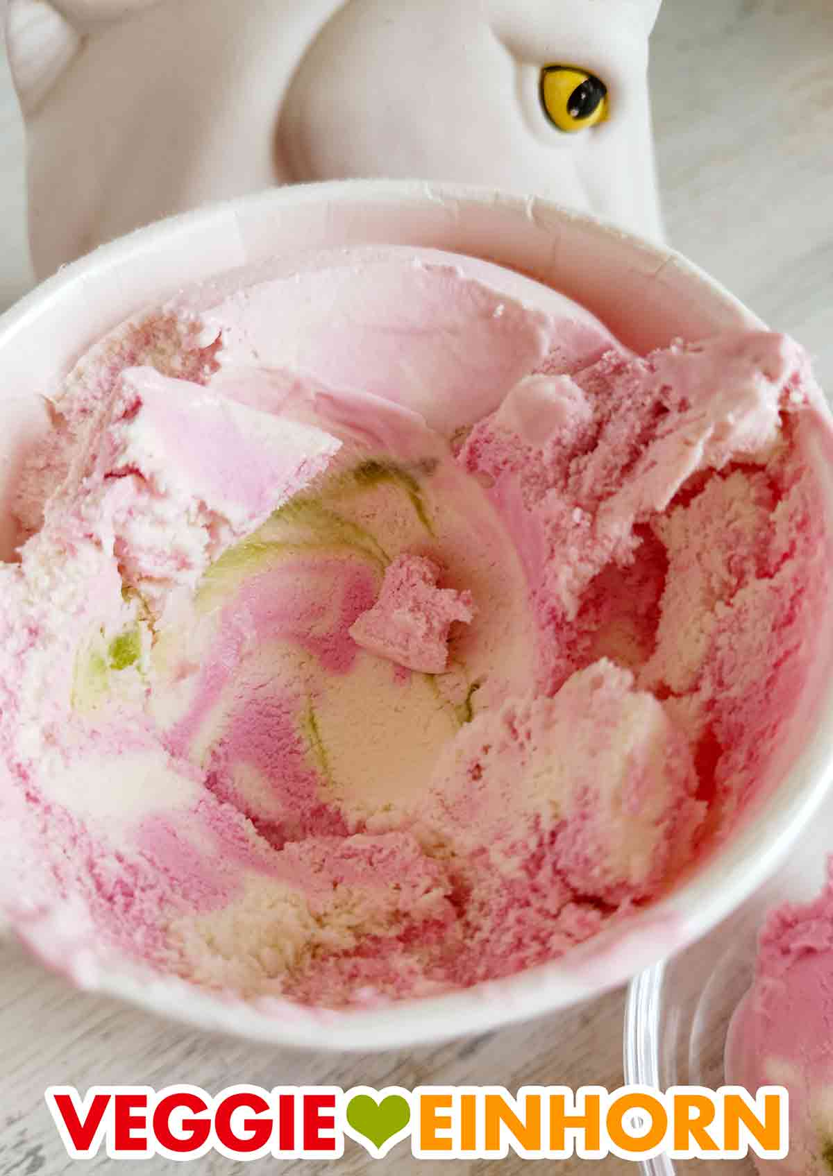 Das vegane Katjes Grün Ohr Hasen Eis besteht aus rosa Eiscreme, weißer Eiscreme und grüner Soße mit Fruchtgeschmack. Katjes Grünohrhasen Eiscreme im geöffneten Becher