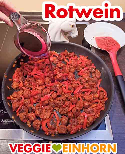 Veganer Rotwein für das vegetarische Gulasch Veganer Rotwein wird in die Pfanne zugefügt