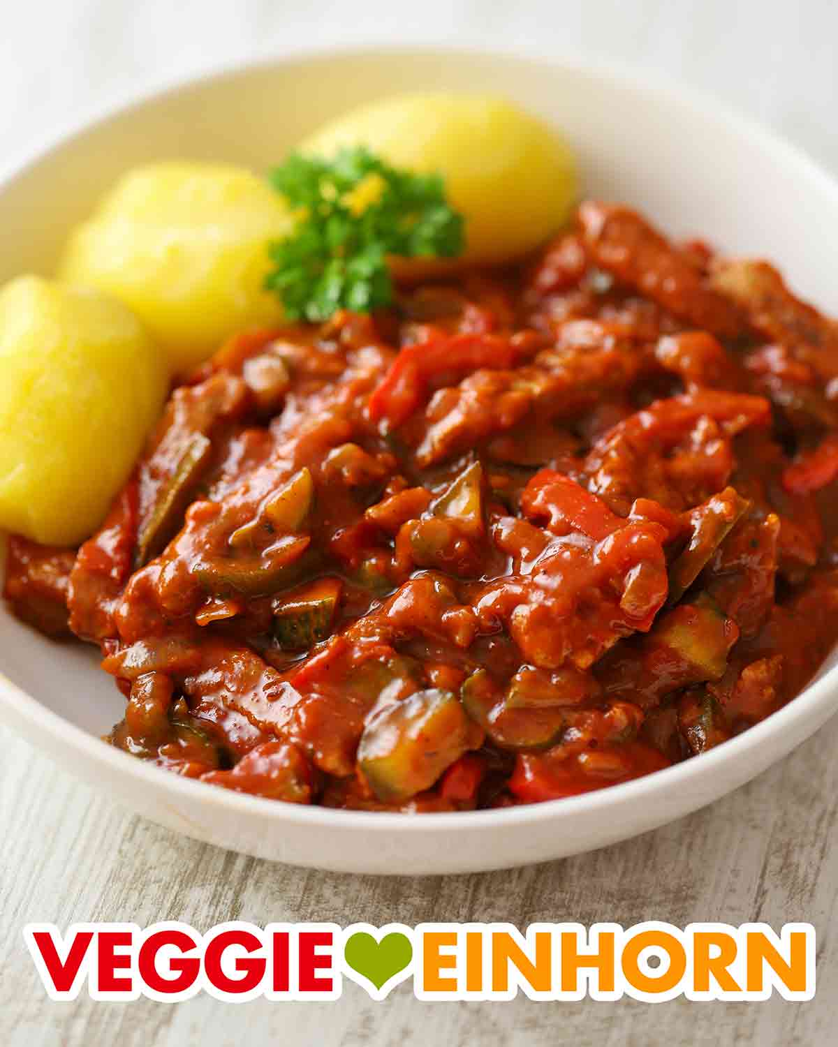 Teller mit veganem Gulasch mit Sojaschnetzeln und Gewürzgurken