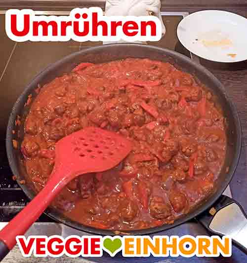 Umrühren des vegetarischen Gulasch Das vegane Gulasch wird umgerührt