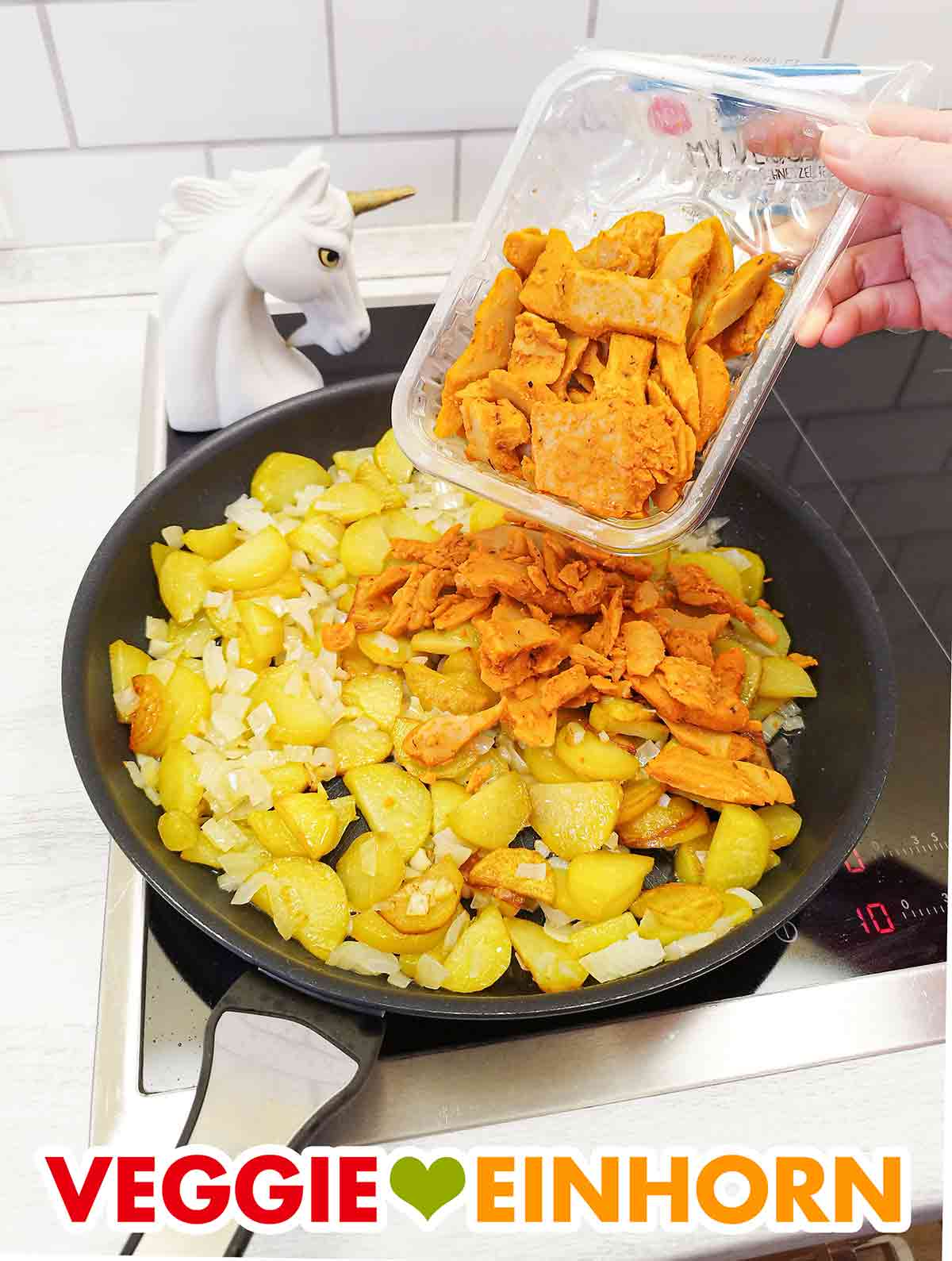 Ich habe das vegane Gyros von EDEKA My Veggie in einer Kartoffel-Gyrospfanne verwendet. Veganes Gyros von Edeka My Veggie wird in eine Pfanne mit angebratenen Kartoffeln und Zwiebeln gegeben
