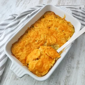Veganes Kartoffelgratin mit veganem Käse überbacken, in einer weißen Auflaufform.