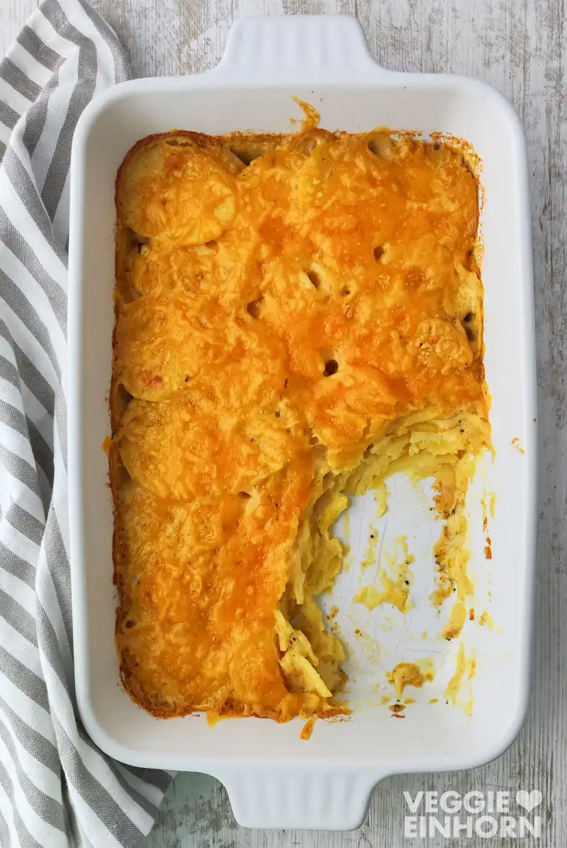 Veganes Kartoffelgratin mit veganem Käse Veganes Kartoffelgratin mit veganem Käse in einer weißen Auflaufform von oben fotografiert.