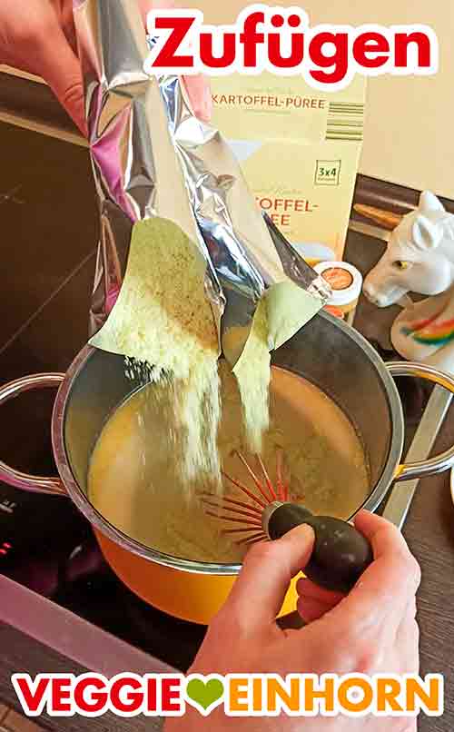 Das Kartoffelpüree Pulver zu der Wasser-Milch-Mischung zufügen. Das vegane Kartoffelpüree Pulver wird in den Topf gegeben.