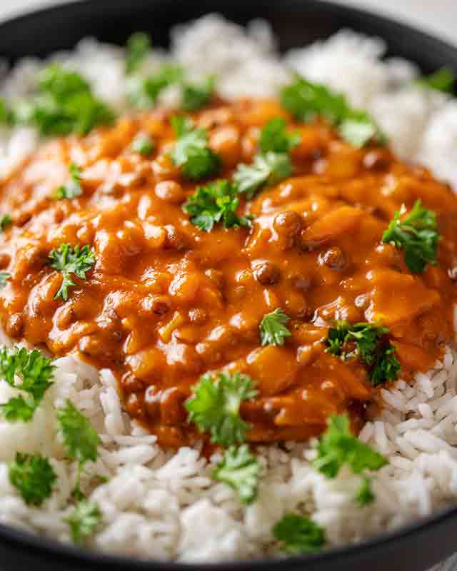 Nahaufnahme von veganem Linsencurry mit Currypaste und Möhren