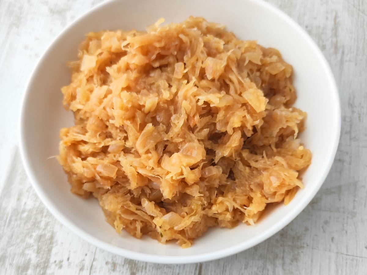 Veganes Sauerkraut in einer weißen Schüssel auf hellem Untergrund.