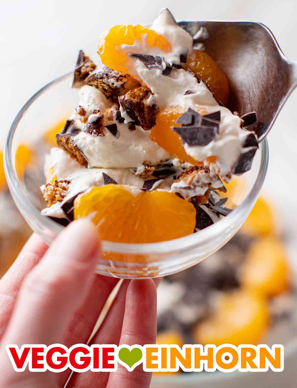 Der weihnachtliche Nachtisch besteht aus einer veganen Dessertcreme, Mandarinen aus der Dose und veganen Lebkuchen. Das vegane Weihnachtsdessert wird in ein Schälchen gegeben